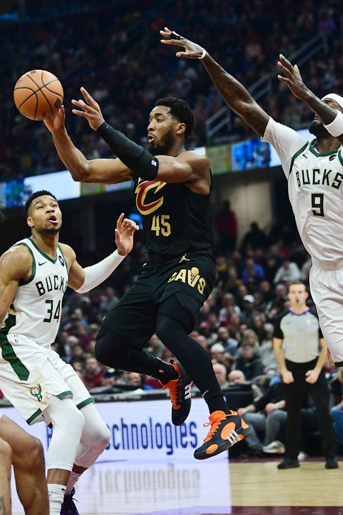 Dec 29, 2023; Cleveland, Ohio, USA; Cleveland Cavaliers guard Donovan Mitchell (45) passes as Milwaukee Bucks forward Giannis Antetokounmpo (34) and forward Bobby Portis (9) defend during the first half at Rocket Mortgage FieldHouse.